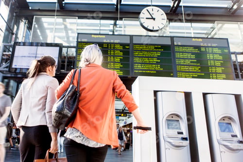 Preview: Travelers checking the flight information display at a busy airport terminal