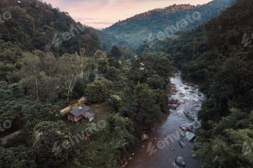 Preview: Wooden cabin in tropical rainforest and natural rapids in the valley