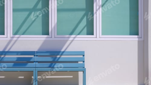 Preview: Wooden benches in front of glass windows and blue sun blinds of vintage white concrete house wall