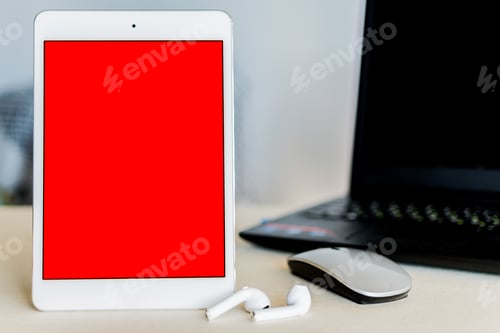 Preview: Tablet with re screen next to a laptop on a desk - technology and business concept