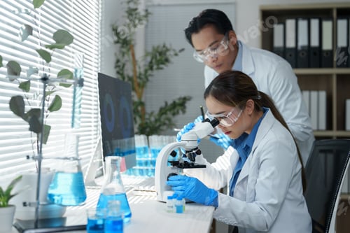 Preview: Two scientists in a laboratory setting are focused on conducting research using a microscope.