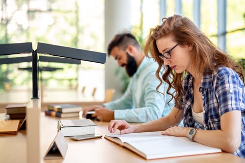 Preview: Happy group of students studying and working together in a college library