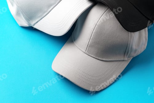 Preview: Baseball caps on blue background studio shot
