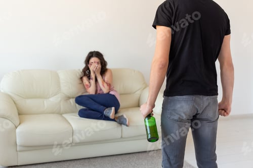 Preview: alcoholic, domestic violence and abuse concept - man gets drunk at home and takes his anger at his