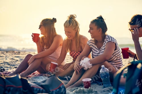 Preview: Good times and tan lines. Shot of young female best friends hanging out at the beach.