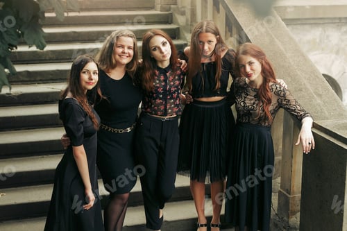 Preview: gorgeous luxury women in black dresses posing smiling on stairs under tree