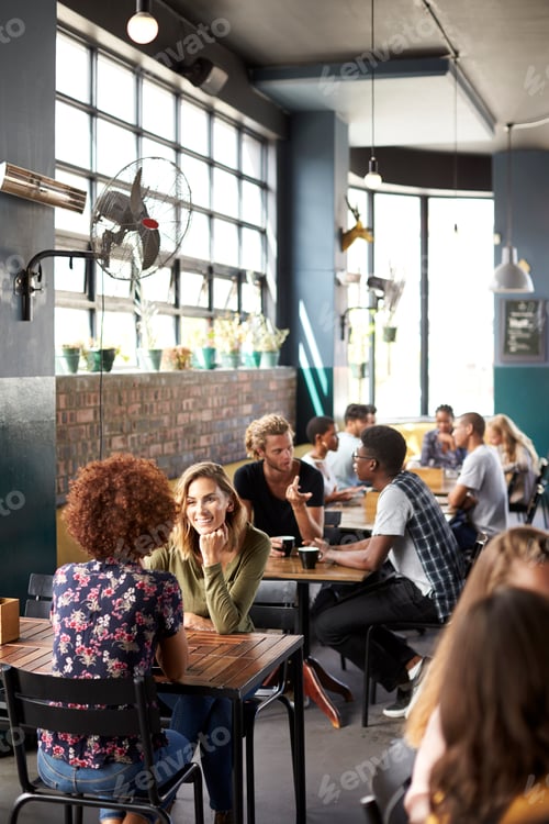 Preview: Interior Of Busy Coffee Shop With Customers Sitting At Tables