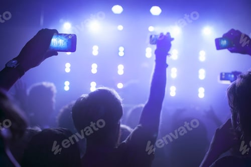 Preview: Group of friends watching and taking photograph of performer in club