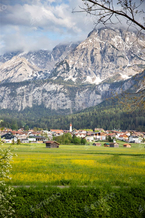 Preview: Beautilful green meadow and alpine village in spring, Austria