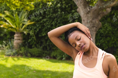 Preview: In garden, woman stretching neck, finding peaceful moment outside in nature, copy space