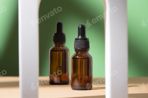 Preview: Beauty collagen face serum in a glass dropper bottles in Arch on green background.