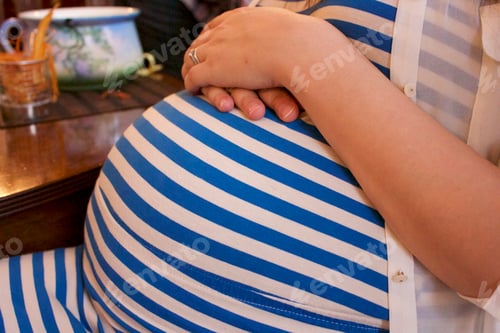 Preview: Pregnant woman resting hands on belly
