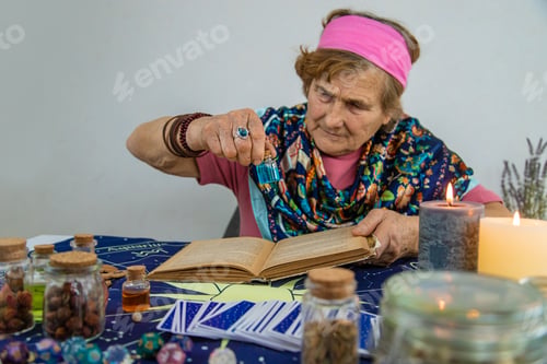 Preview: Woman fortune teller prepares a potion. Selective focus.