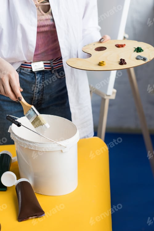 Preview: Young creative girl mixing paint in light studio