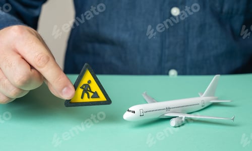 Preview: A man holds a construction or repair symbol near a passenger plane. Technical inspection.
