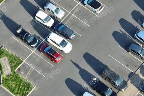 Preview: Aerial view of many colorful cars parked on parking lot with lines and markings