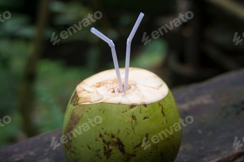 Preview: Coconut with straws in blurred background