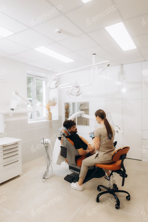 Preview: Dentist preparing patient for treatment in modern dental clinic