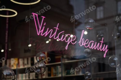 Preview: Pink neon sign reading 'Vintage Beauty' in a shop window display