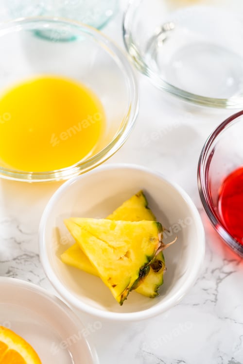 Colorful Bowls of Pineapple, Juices on White Table