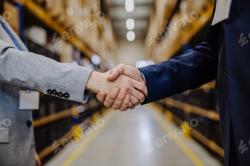 Preview: Close-up of managers shaking hands in warehouse.