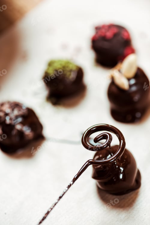Preview: close up of swirl with melted chocolate near chocolate balls