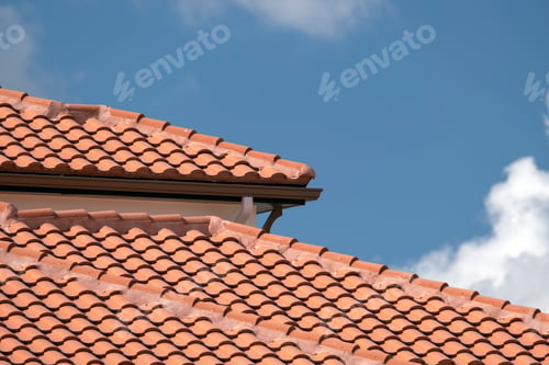 Preview: Overlapping rows of yellow ceramic roofing tiles covering residential building roof