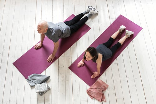 Preview: Active elderly people working out on the exercise mats at home