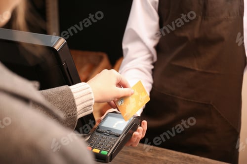 Preview: Woman with credit card using payment terminal at shop, closeup