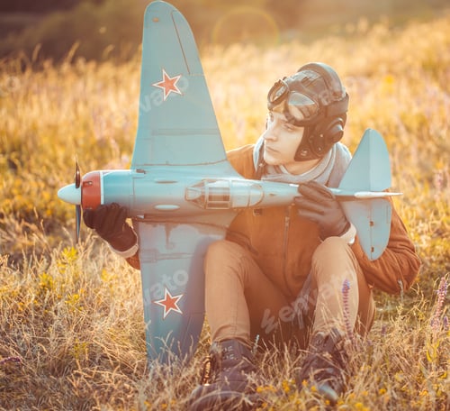 Vista previa: Guy in vintage clothes pilot with an airplane model outdoors