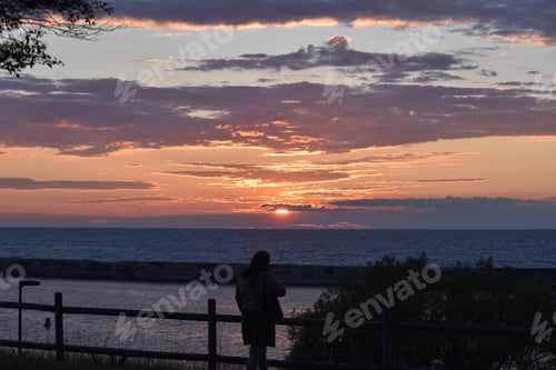 Preview: Woman watching a Gorgeous sunset on Lake Ontario