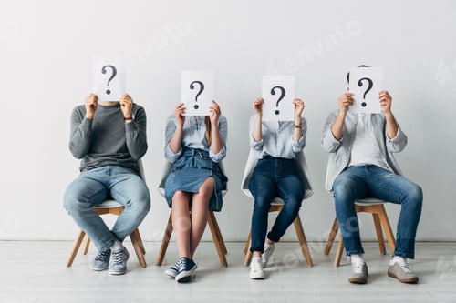 Preview: Young people holding cards with question marks while waiting for job interview in office