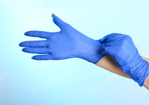 Preview: Woman putting on latex gloves against light blue background, closeup of hands