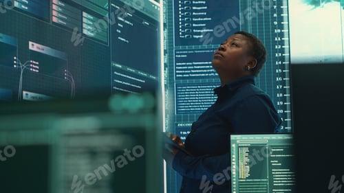 Preview: Cyber intelligence specialist examines data on big screen in governmental agency