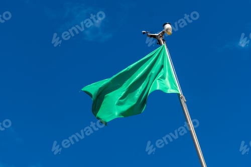 Preview: Green flag on the beach in summer summer, lifeguards sign that you can swim