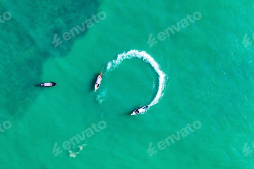 Preview: Aerial view of traditional longtail boats floating on a turquois