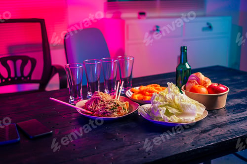 Preview: A beer glass and various food drink items are placed on table in a party room.The space is empty