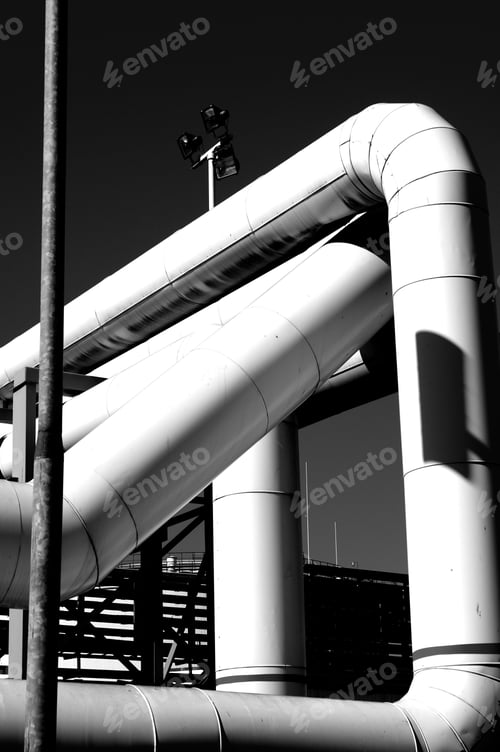 Preview: Grayscale shot of big pipelines in the industrial area
