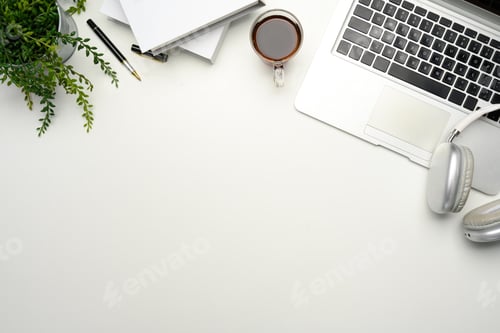 Preview: Minimalist workspace with laptop, coffee cup, headphones and notebooks on white desk