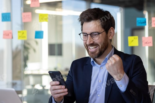 Preview: A man in a suit is smiling and holding a cell phone