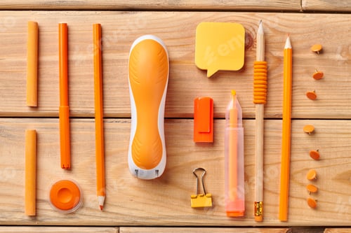 Preview: Orange stationery supplies on wooden background.