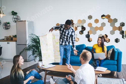 Preview: Black man demonstrating map to laughing friends in living room