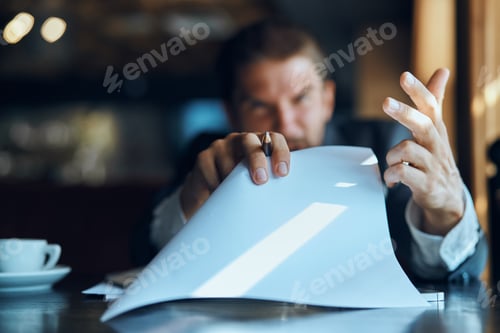 Preview: business man sitting at a table in a cafe documents work official coffee cup