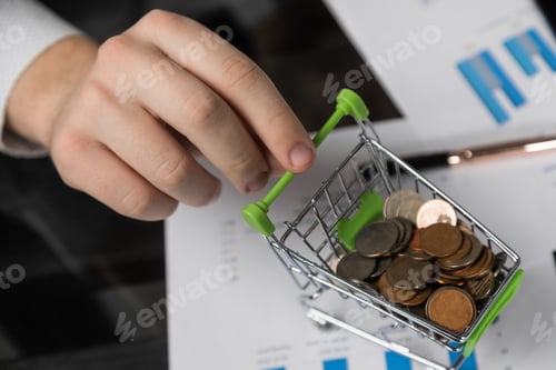 Preview: man's hand holds a Dummy shopping cart filled with coins