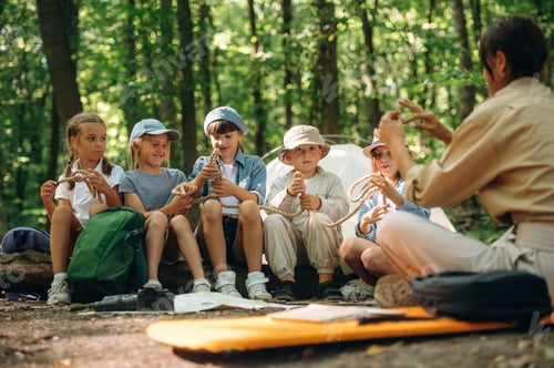 Preview: Survival tips, sitting at camp. Woman is doing tour for group of kids in the forest