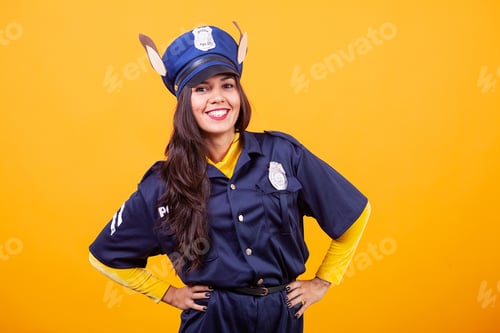 Preview: Beautiful young woman wearing Police costume over yellow background