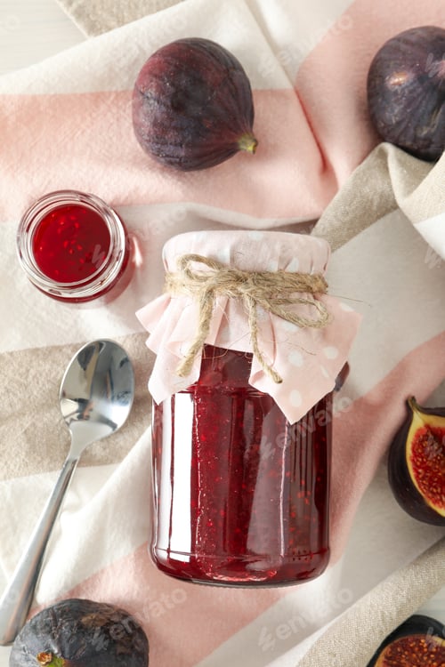Preview: Figs, jars of jam and towel on light background, top view