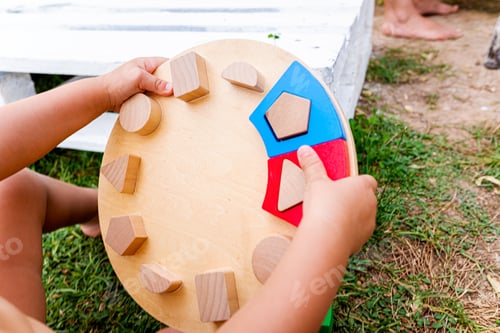 Preview: Detail of a baby playing and manipulating a geometric puzzle