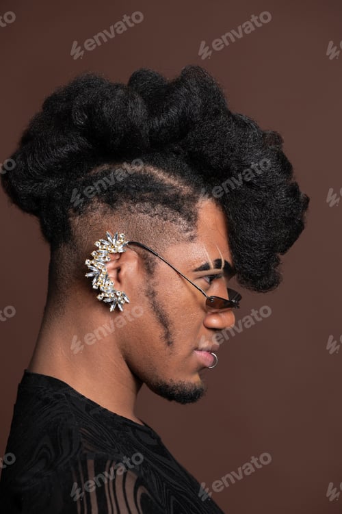 Preview: Young model posing with stylish hairstyle and earring, side view portrait