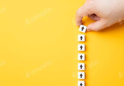 Preview: Hand making a row of arrows on a yellow background.